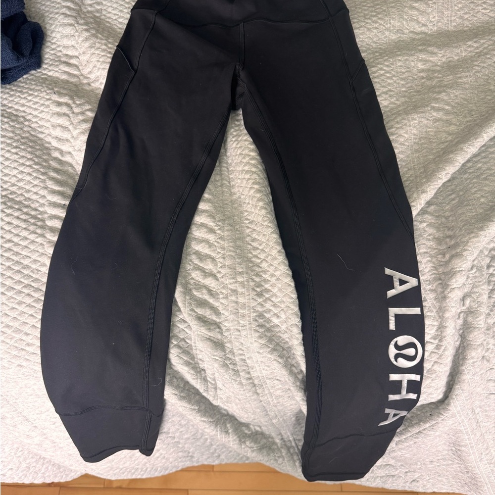 Lululemon Black Leggings with Aloha in leg.